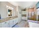 Bright bathroom features double sinks with decorative countertops, tiled floor, and glass enclosed shower at 17138 W Las Palmaritas Dr, Waddell, AZ 85355