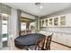 Elegant dining room with a dark wood table, upholstered chairs, and bright windows that provide a view of the outdoors at 17138 W Las Palmaritas Dr, Waddell, AZ 85355