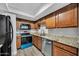 Renovated kitchen featuring modern appliances, granite countertops, and wood-toned cabinets at 17211 N 35Th Ave, Phoenix, AZ 85053