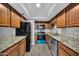 Modern kitchen featuring stainless steel appliances, granite countertops, and wood cabinetry at 17211 N 35Th Ave, Phoenix, AZ 85053