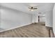 Spacious room with wood-look flooring and a ceiling fan, offering a bright and airy atmosphere with a glimpse into the kitchen at 17211 N 35Th Ave, Phoenix, AZ 85053