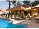 Inviting community pool with lounge chairs and tables with chairs under umbrellas for relaxing by the water at 17211 N 35Th Ave, Phoenix, AZ 85053