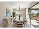 Bright dining room features a large wooden table, chandelier, and sliding glass doors to the patio at 17963 E Silver Sage Ln, Rio Verde, AZ 85263