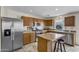 Well-lit kitchen featuring stainless steel appliances, a kitchen island with seating, and tile flooring at 1992 E Shetland Dr, San Tan Valley, AZ 85140