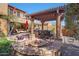 Backyard features a fire pit, outdoor kitchen, pergola, and lush landscaping at 20785 W Canyon Dr, Buckeye, AZ 85396