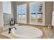 Soaking tub featuring white shutters, tile accents, and plenty of natural light at 20785 W Canyon Dr, Buckeye, AZ 85396