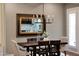 Elegant dining room features a modern chandelier, a dark wood table, and a decorative mirror for a sophisticated look at 20785 W Canyon Dr, Buckeye, AZ 85396