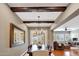 Dining room featuring exposed beam ceiling, wood floors, and views into the living room at 20785 W Canyon Dr, Buckeye, AZ 85396