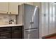 Showcases a stainless steel refrigerator, contrasting dark lower cabinets and light upper cabinets to maximize storage at 20785 W Canyon Dr, Buckeye, AZ 85396