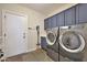 Well-equipped laundry room featuring modern washer and dryer, ample storage, and durable tile flooring at 20785 W Canyon Dr, Buckeye, AZ 85396