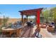 Outdoor kitchen under a pergola with dining area and a stone fire pit at 20785 W Canyon Dr, Buckeye, AZ 85396