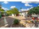 Charming backyard featuring mature trees, gravel landscaping, and a covered patio area at 238 N 62Nd St, Mesa, AZ 85205