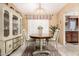 Cozy dining room with a vintage china cabinet, a round table, and a decorative chandelier at 238 N 62Nd St, Mesa, AZ 85205