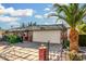 View of a charming single-story house with a well-kept front garden, covered carport, and stone accents at 238 N 62Nd St, Mesa, AZ 85205