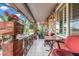 Covered front porch with stone accents, tiled flooring, and a cozy seating area overlooking the yard at 238 N 62Nd St, Mesa, AZ 85205