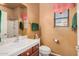 This bathroom features a sink with cherry cabinets, white countertops, a shower, and a toilet at 25609 N 54Th Ln, Phoenix, AZ 85083