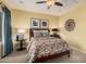 A comfy bedroom shows warm color tones, ceiling fan and window providing natural light at 25609 N 54Th Ln, Phoenix, AZ 85083