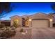 Inviting desert-landscaped home with a two-car garage and warm lighting at 25609 N 54Th Ln, Phoenix, AZ 85083