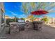 View of the backyard outdoor kitchen with built in grill, stone surround and brick pavers at 25609 N 54Th Ln, Phoenix, AZ 85083