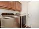 Laundry room with side by side washer and dryer set and wooden cabinets above at 2646 N Robin Ln, Mesa, AZ 85213