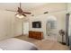 Spacious main bedroom with a ceiling fan, tv, dresser and ensuite bathroom with a soaking tub at 2646 N Robin Ln, Mesa, AZ 85213