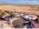 Aerial view showcasing a home with desert landscaping, circular driveway, and a rural street at 26649 S Howard Dr, Sun Lakes, AZ 85248