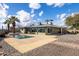 Back exterior showcases the pool, sunroom, and desert landscaping under a blue sky at 26649 S Howard Dr, Sun Lakes, AZ 85248