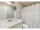 Bathroom with a large mirror, shower with curtain, sink, and toilet at 26649 S Howard Dr, Sun Lakes, AZ 85248