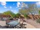 Paver patio with table and chairs offering a great space for outdoor dining and relaxing in a beautifully landscaped backyard at 27108 W Escuda Dr, Buckeye, AZ 85396