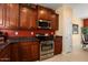 Kitchen featuring stainless steel appliances, dark wood cabinetry, and tile flooring at 27108 W Escuda Dr, Buckeye, AZ 85396