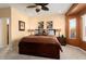 Large main bedroom with a ceiling fan, side tables, and a scenic window view at 27108 W Escuda Dr, Buckeye, AZ 85396