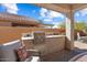 Covered outdoor kitchen is equipped with a built-in grill and counter space, perfect for entertaining at 27108 W Escuda Dr, Buckeye, AZ 85396