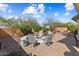 Paver patio with a stone fire pit surrounded by swivel chairs and mature desert landscaping, perfect for outdoor entertaining at 27108 W Escuda Dr, Buckeye, AZ 85396