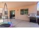 A covered back patio is shown with a hanging swing, grill, and sliding glass door entry at 28871 N Coal Ave, San Tan Valley, AZ 85143