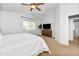 Main bedroom features a ceiling fan, plush carpet, white bedding and a view to the rear yard at 28871 N Coal Ave, San Tan Valley, AZ 85143