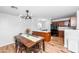 Combined dining and kitchen area with modern light fixtures, wooden cabinets, and tiled backsplash at 28871 N Coal Ave, San Tan Valley, AZ 85143