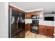 Bright kitchen features white subway tile, wood cabinets, black appliances, quartz counters, and wood-look floors at 28871 N Coal Ave, San Tan Valley, AZ 85143