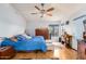 Bedroom featuring a ceiling fan, light wood flooring, blue comforter, dresser, and outside door at 3034 N Ricardo --, Mesa, AZ 85215