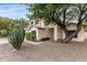 Charming two-story home with desert landscaping, large shade tree, and stucco pillars on the front porch at 3034 N Ricardo --, Mesa, AZ 85215