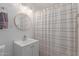 A neat bathroom with a vanity, and a shower area with a curtain and lighting at 3129 W Pierce St, Phoenix, AZ 85009