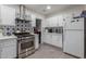 Clean white kitchen boasts stainless steel appliances and stylish backsplash at 3129 W Pierce St, Phoenix, AZ 85009