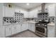 Bright kitchen features starburst backsplash, stainless steel appliances, and white cabinets at 3129 W Pierce St, Phoenix, AZ 85009