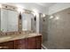 Bathroom featuring double vanity sinks, granite countertops, large mirrors, and walk-in shower at 3428 E Lance Ln, Phoenix, AZ 85018