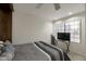 Well-lit bedroom featuring a large window, ceiling fan, and comfortable, neutral decor at 3428 E Lance Ln, Phoenix, AZ 85018