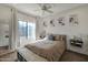 Sunlit bedroom featuring a large window, ceiling fan, and comfortable, neutral decor at 3428 E Lance Ln, Phoenix, AZ 85018