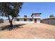 Wide open backyard space with a white house with red door and grey perimeter wall at 3547 W Encanto Blvd, Phoenix, AZ 85009