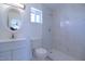 Modern bathroom with a large, round mirror, white vanity, and a luxurious, marble-tiled shower at 3547 W Encanto Blvd, Phoenix, AZ 85009