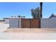 Wooden gate nestled within a cinder block wall enhancing privacy and security to the property at 3547 W Encanto Blvd, Phoenix, AZ 85009