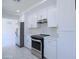 Modern kitchen with white cabinets, stainless steel appliances and marble-look tile flooring at 3547 W Encanto Blvd, Phoenix, AZ 85009