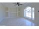 Spacious living room featuring a large window, custom built-ins, and modern tile flooring at 3547 W Encanto Blvd, Phoenix, AZ 85009